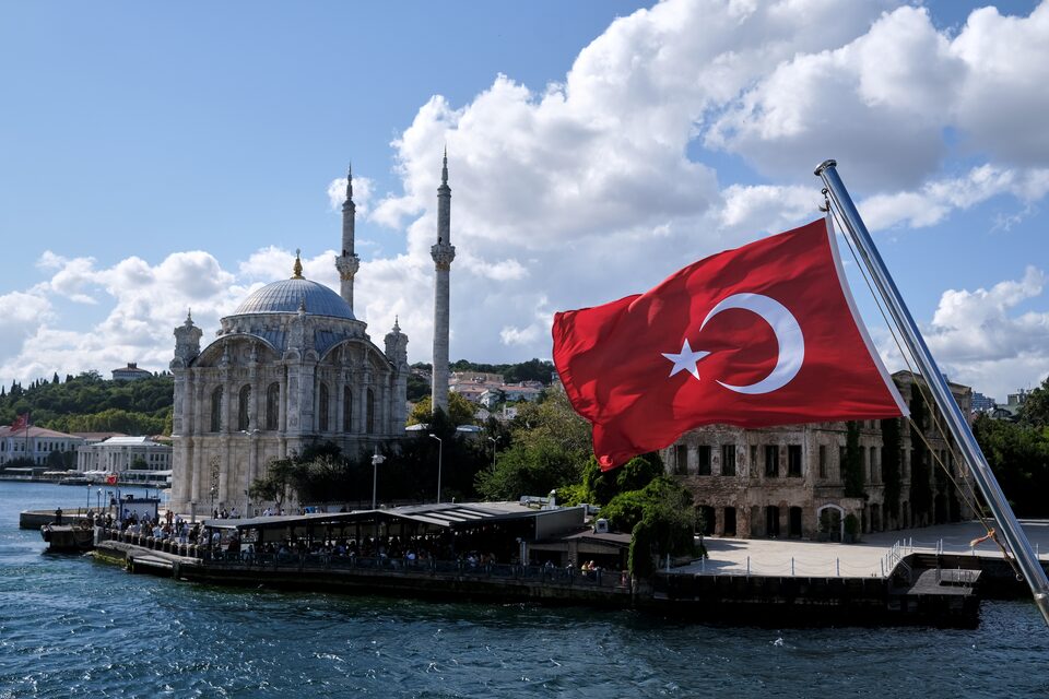 A Turkish flag is pictured on a boat with the Ortakoy Mosque in the background in Istanbul, Türkiye September 5, 2021. (Reuters Photo)