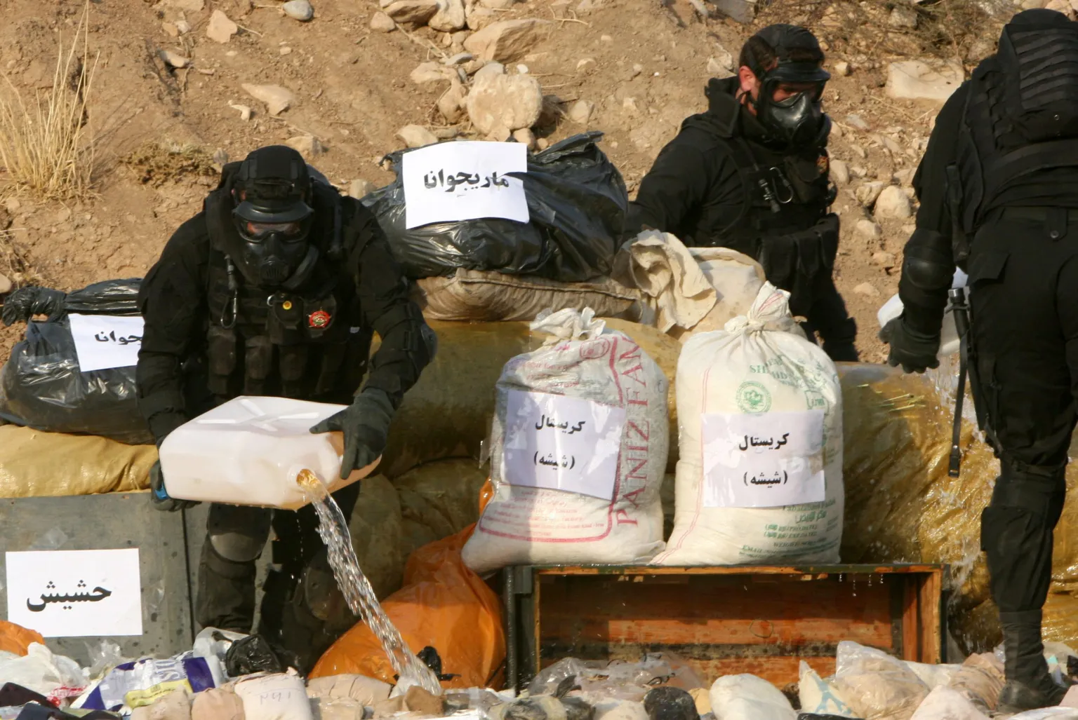 Members of the Iraqi security forces pour gasoline over a seized drug haul before they burn it in the northern city of Erbil in 2013. (AFP Photo)