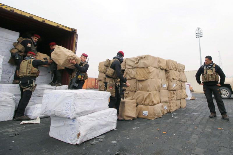Iraqi security forces stand next to stacks of boxes containing drugs at Umm Qasr port in Basra, Iraq. (Reuters Photo)