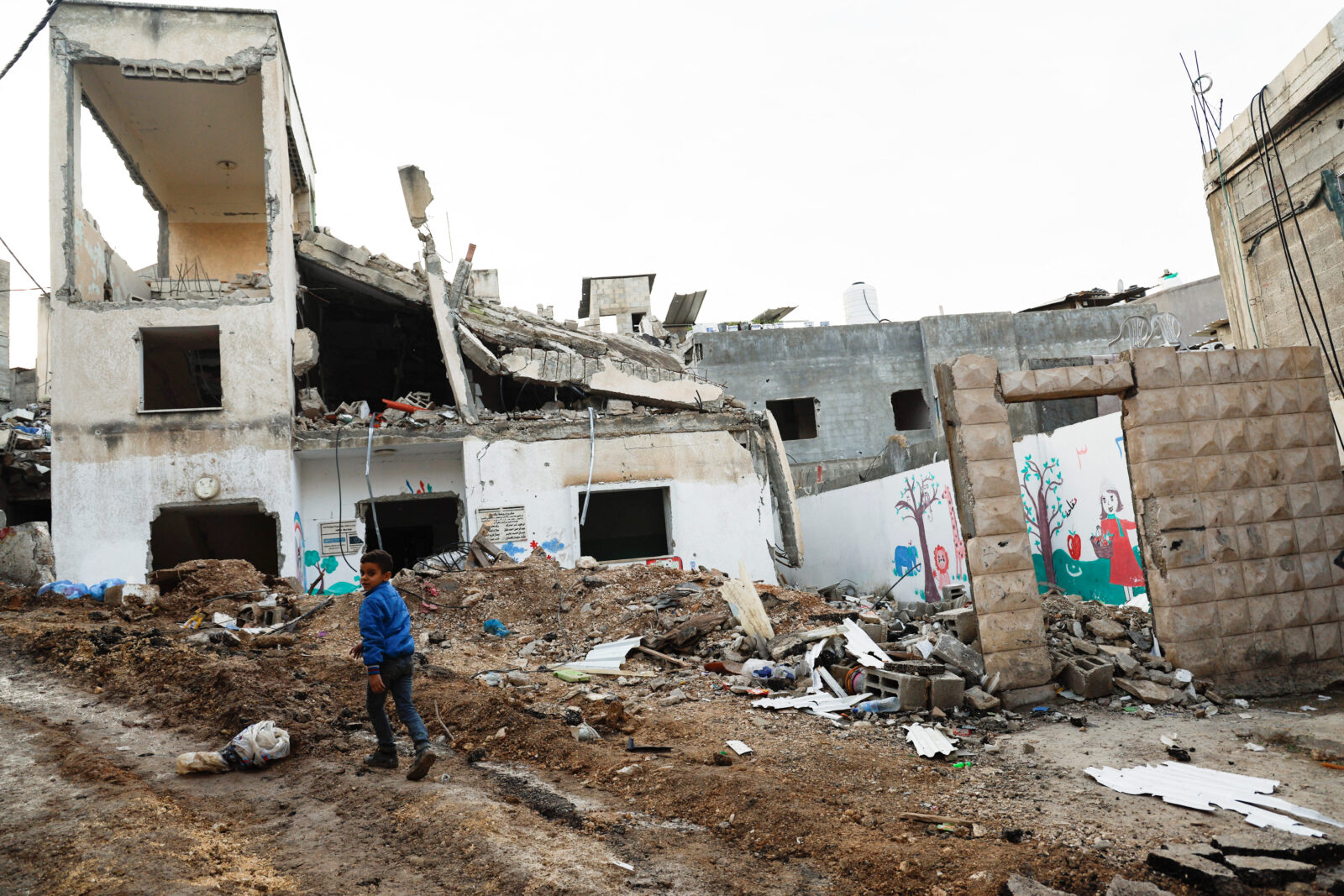 A boy walks near a damaged building after an Israeli raid, at Nour Shams refugee camp in Tulkarm, in occupied West Bank, Jan. 18, 2024. (Reuters Photo)