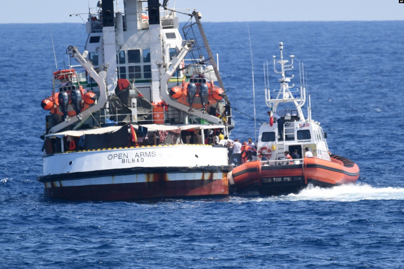 An Italian Coast Guard boat, right, approaches the Spanish humanitarian rescue ship Open Arms, off the Sicilian island of Lampedusa, southern Italy, Aug. 20, 2019.