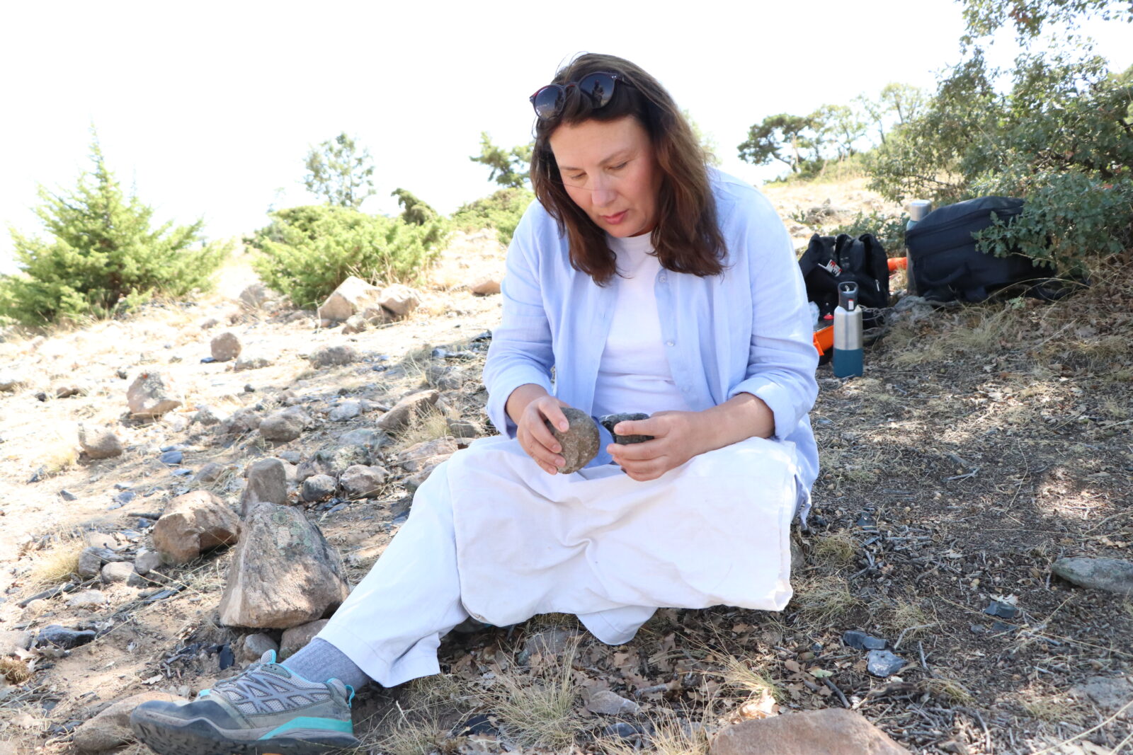 Assoc. Professor Nurcan Kayacan at Golludag excavations, examining obsidian artifacts that offer valuable insights into prehistoric trade and migration patterns, Nigde, Türkiye, September 3, 2024 (AA Photo)
