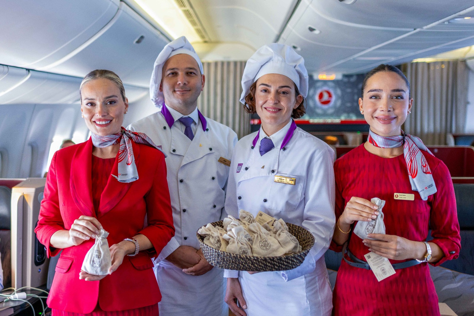 Cabin crew of Turkish Airlines pose with "the world's first bread" from the famed ancient site of Gobeklitepe to be served to passengers during New York flight from Istanbul, Turkiye on September 22, 2024. (AA Photo)