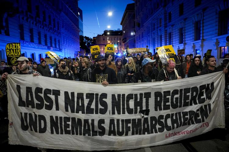 People carry a banner that reads ''Don't let Nazis rule and never march''
