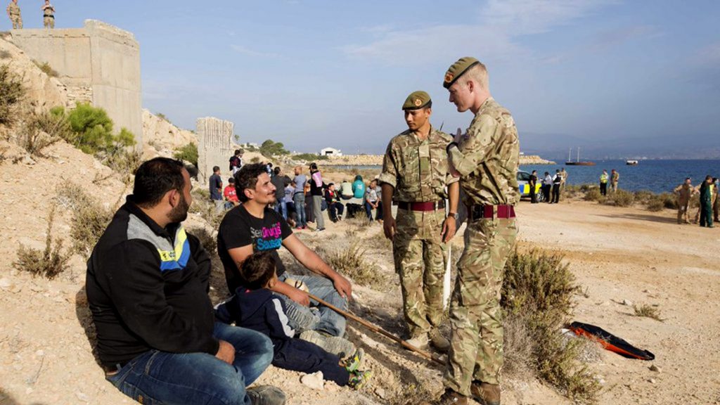 UK soldiers with migrants landed at Akrotiri near Limassol. (Photo: AAP via AP/British Forces Cyprus.)