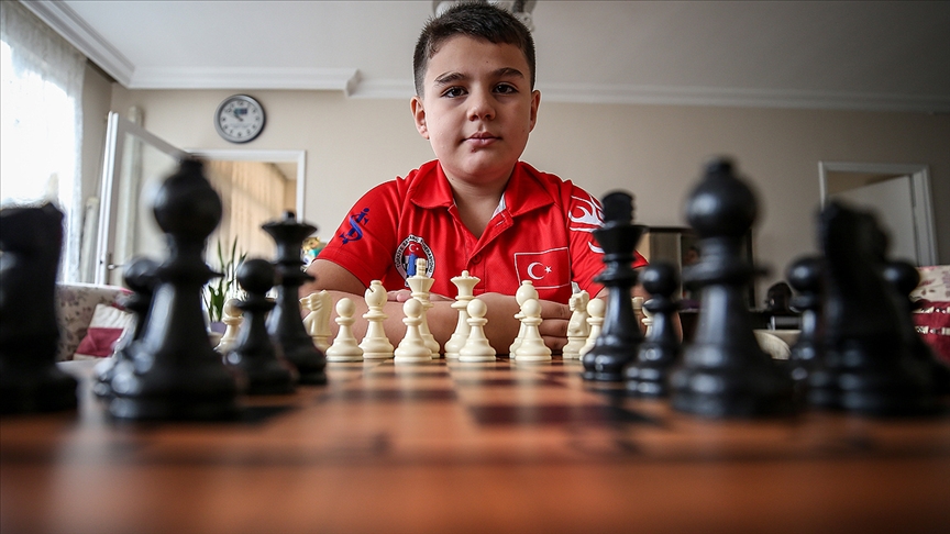 Yagiz Kaan Erdogmus, Türkiye's youngest grandmaster, proudly posing with a chessboard and pieces. His early achievements in the chess world highlight Türkiye’s growing prominence in producing exceptional young talents, Ankara, Türkiye, August 02, 2021. (AA Photo)