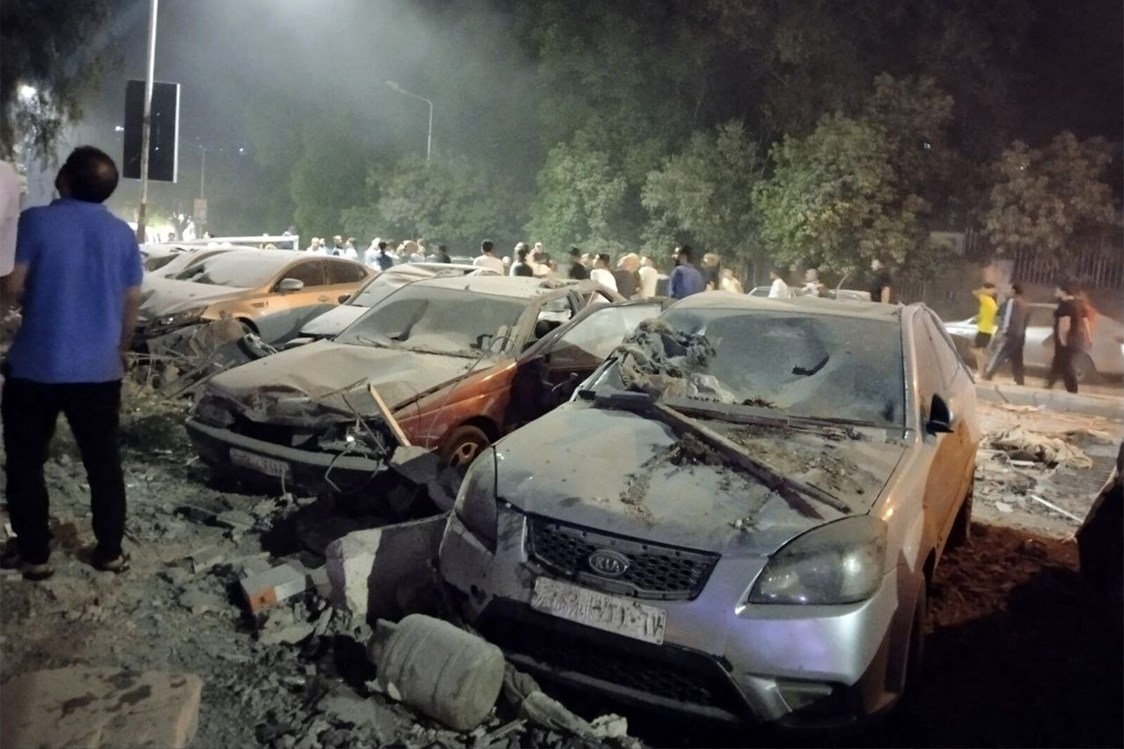 People gather by damaged vehicles at the site of a reported Israeli air strike on a residential building in the Mazzeh suburb on the western outskirts of Damascus, Syria, October 8, 2024. (AFP Photo)