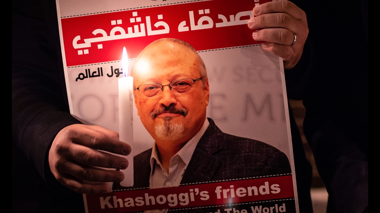 A demonstrator holds a poster picturing Saudi journalist Jamal Khashoggi and a lightened candle during a gathering outside the Saudi Arabia consulate in Istanbul, on October 25, 2018. (AFP / Yasin Akgul)