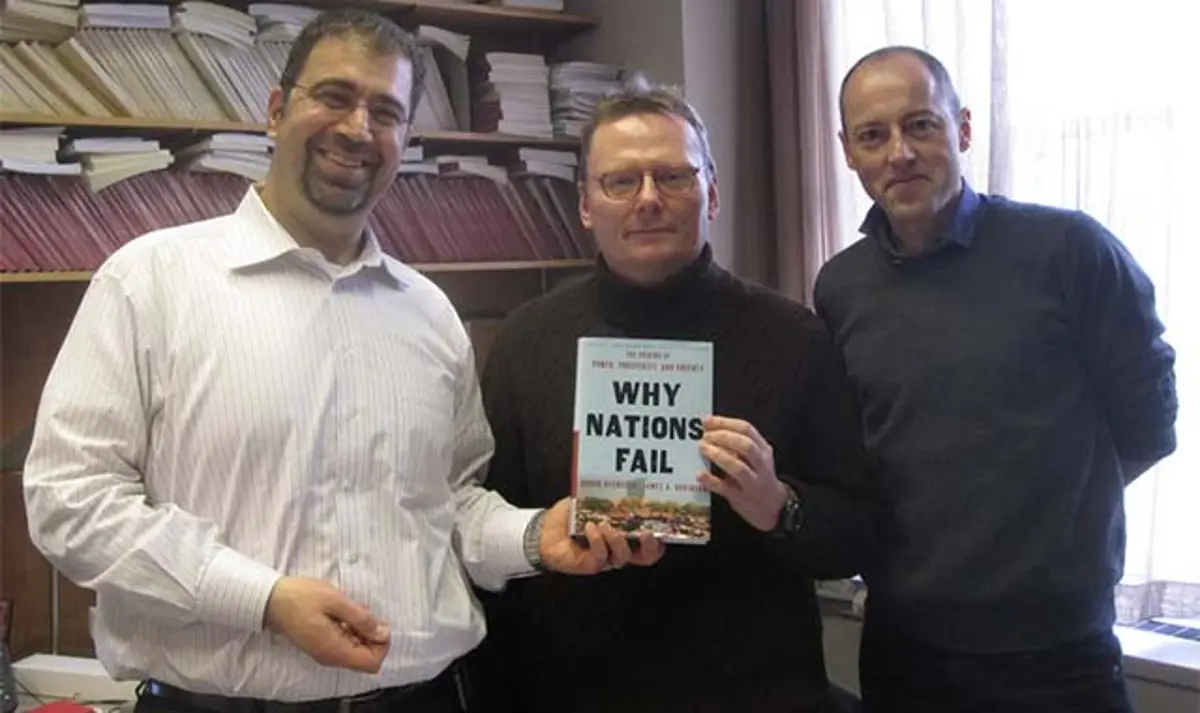 Daron Acemoglu and James Robinson holding their best-selling book, 