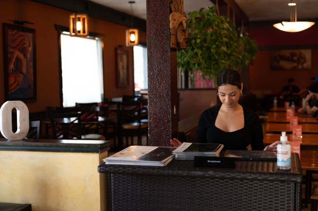 Receptionist welcoming customers at the restaurant entrance (Photo via Spoton)