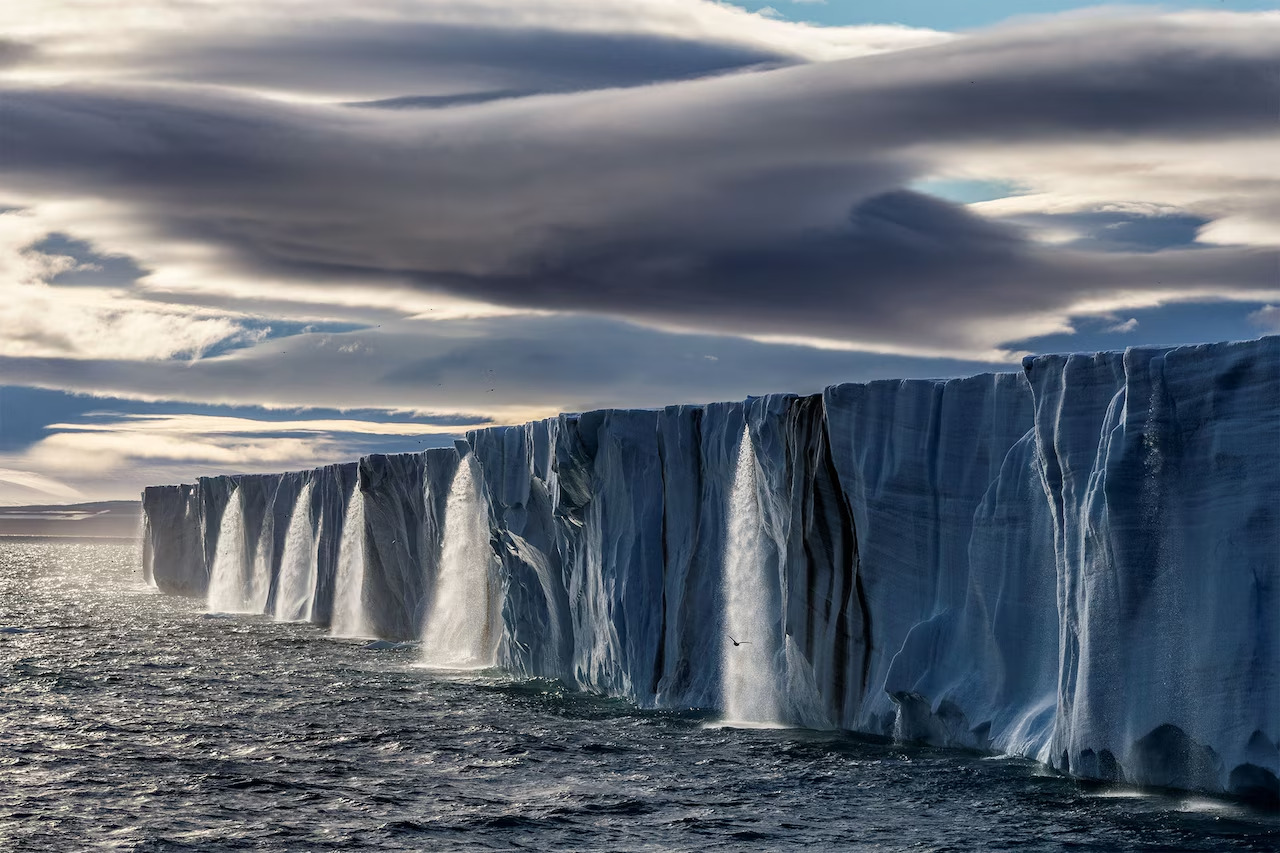 Meltwater gushes from an ice cap on the island of Nordaustlandet, in Norway's Svalbard archipelago. (Photo via Paul Nicklen, Nat Geo Image Collection)