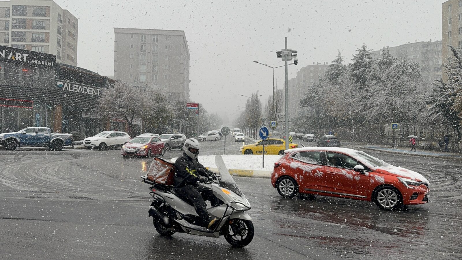 Cars and a motor courier move in traffic during snowfall in Istanbul, Turkiye on Nov. 23, 2024. (AA Photo)