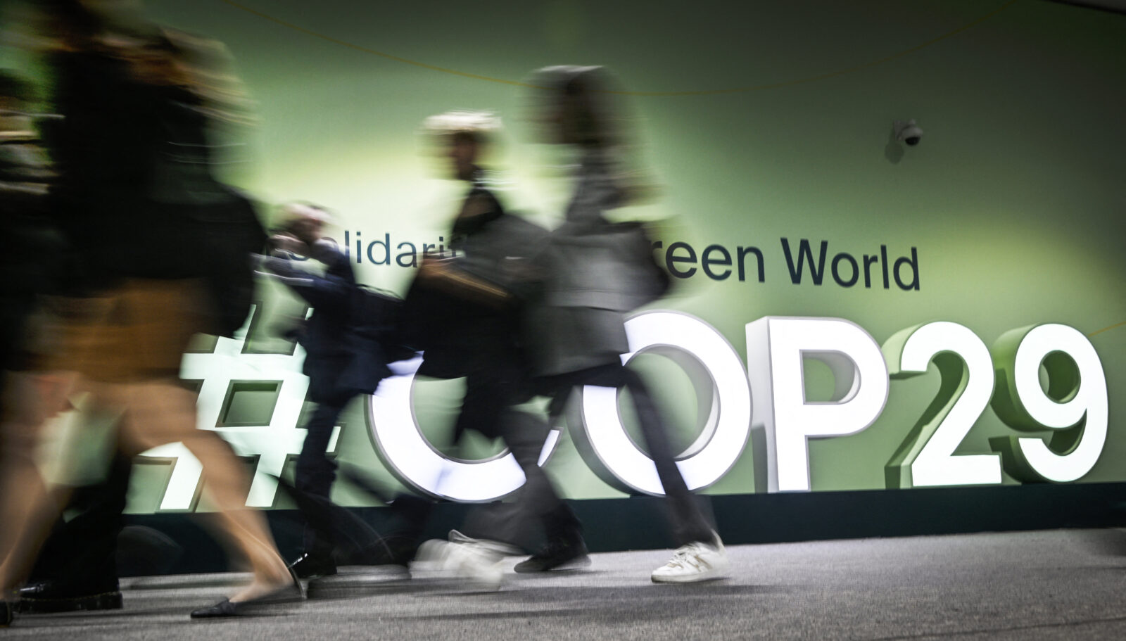 People walk past the logotype at the venue for the 2024 United Nations Climate Change Conference (COP29) in Baku on November 11, 2024. (AFP Photo)