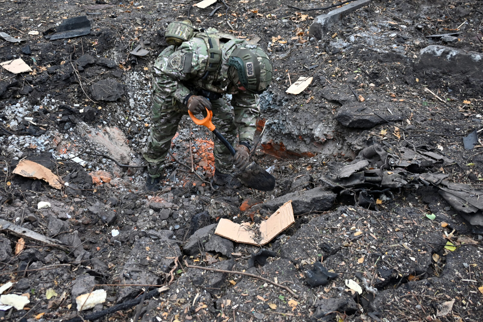 A Ukrainian law enforcement officer instects a crater in the courtyard of a residential building following a missile attack in Kharkiv on November 25, 2024. (AFP Photo)<img src=