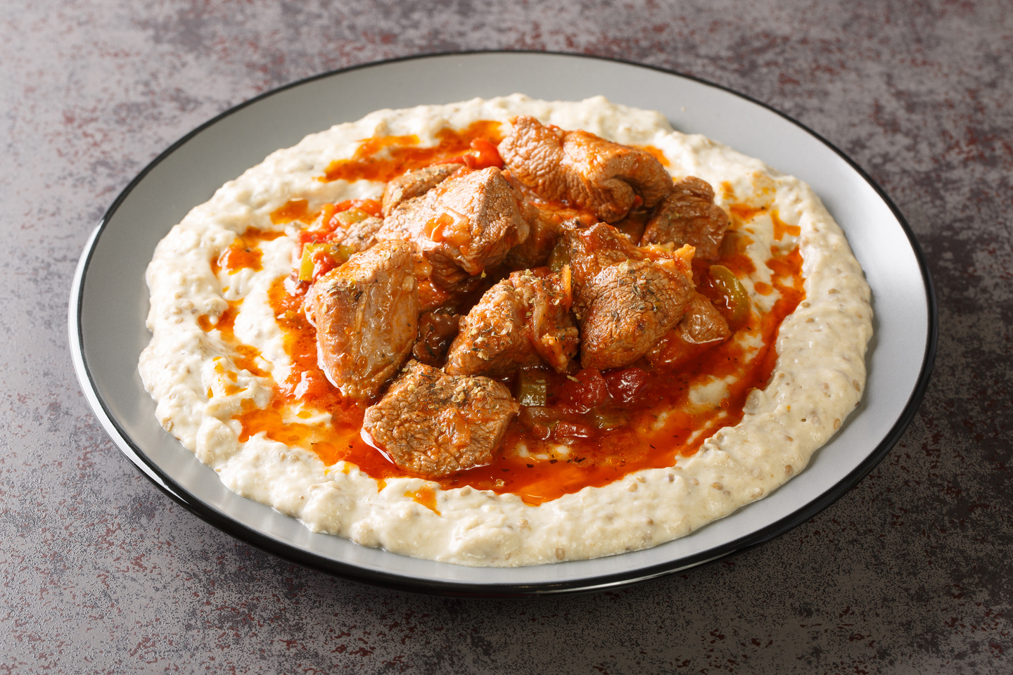Sultan's Delight or Hunkar Begendi is a regal dish of smoked eggplant puree topped with tender, slow-cooked lamb or beef. (Adobe Stock Photo)