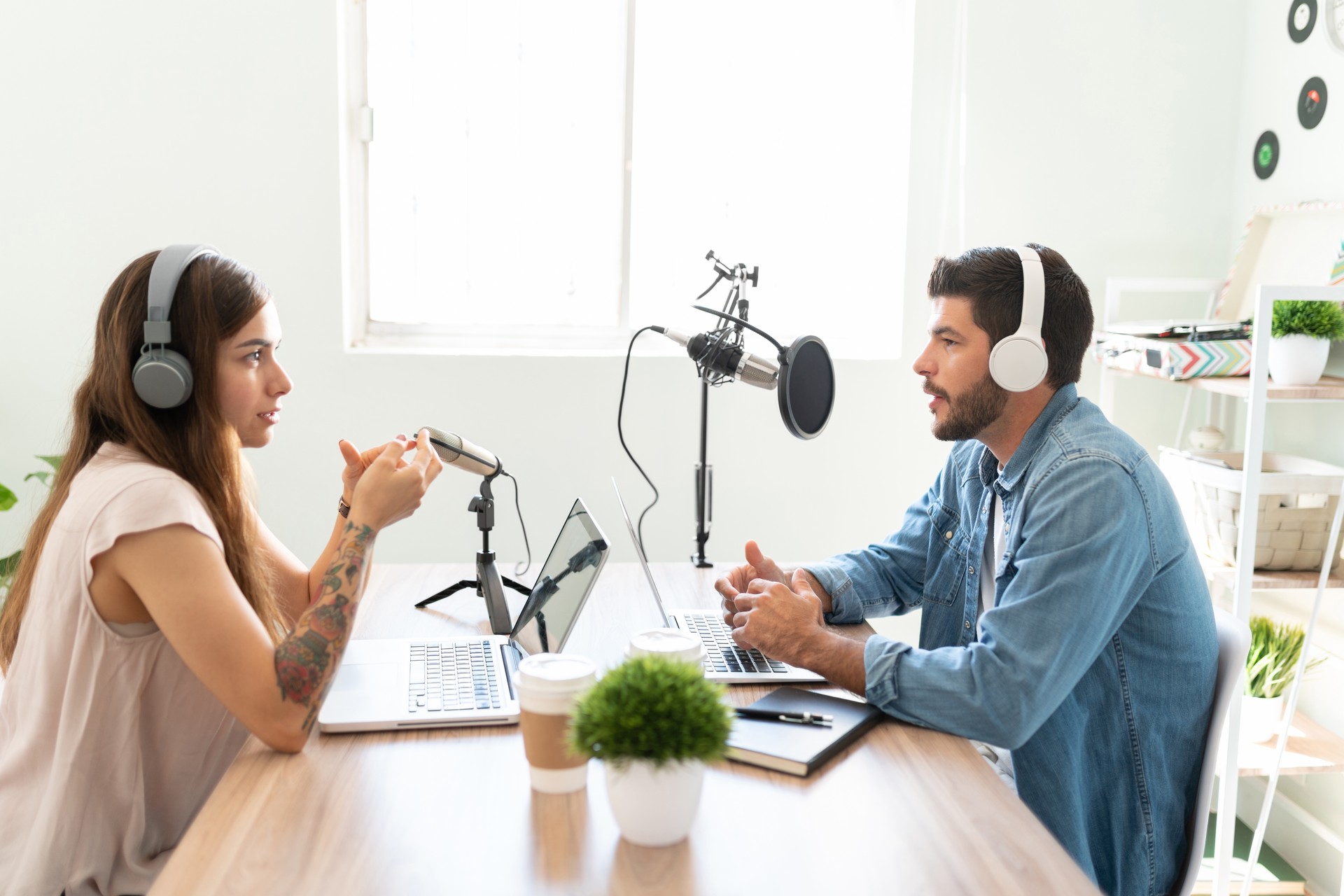 A woman and man are talking in a studio for a podcast recording, in 2024. (Getty Images)