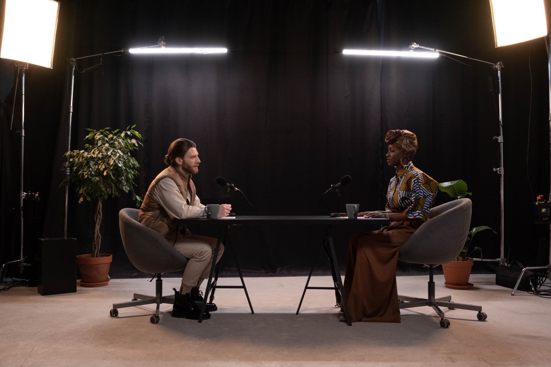 A woman and man are talking in a studio for a podcast recording, 2024. (Getty Images)