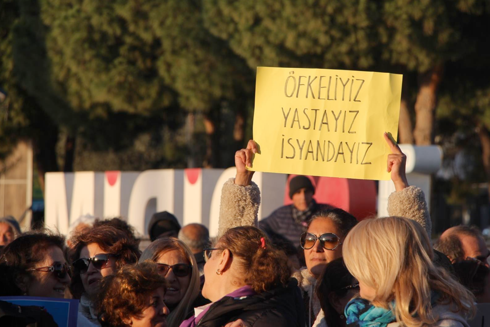 A woman holds a sign that reads, 