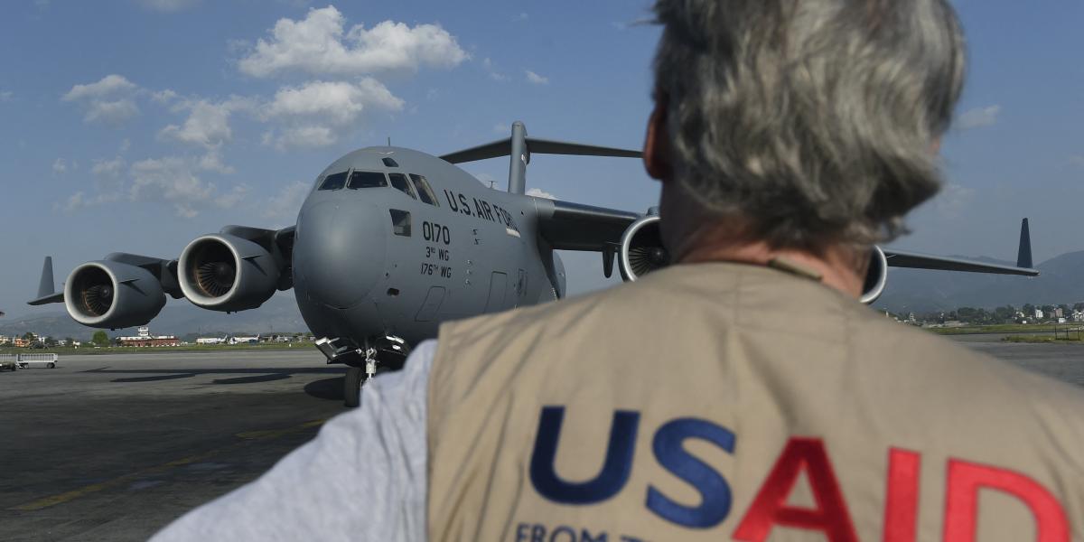 USAID member with a US Air Force Boeing C-17 Globemaster III plane. (USAID Photo)