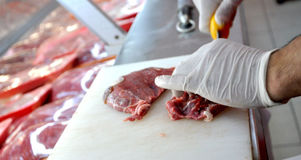 A butcher prepares raw meat by cutting it. (IHA Photo)