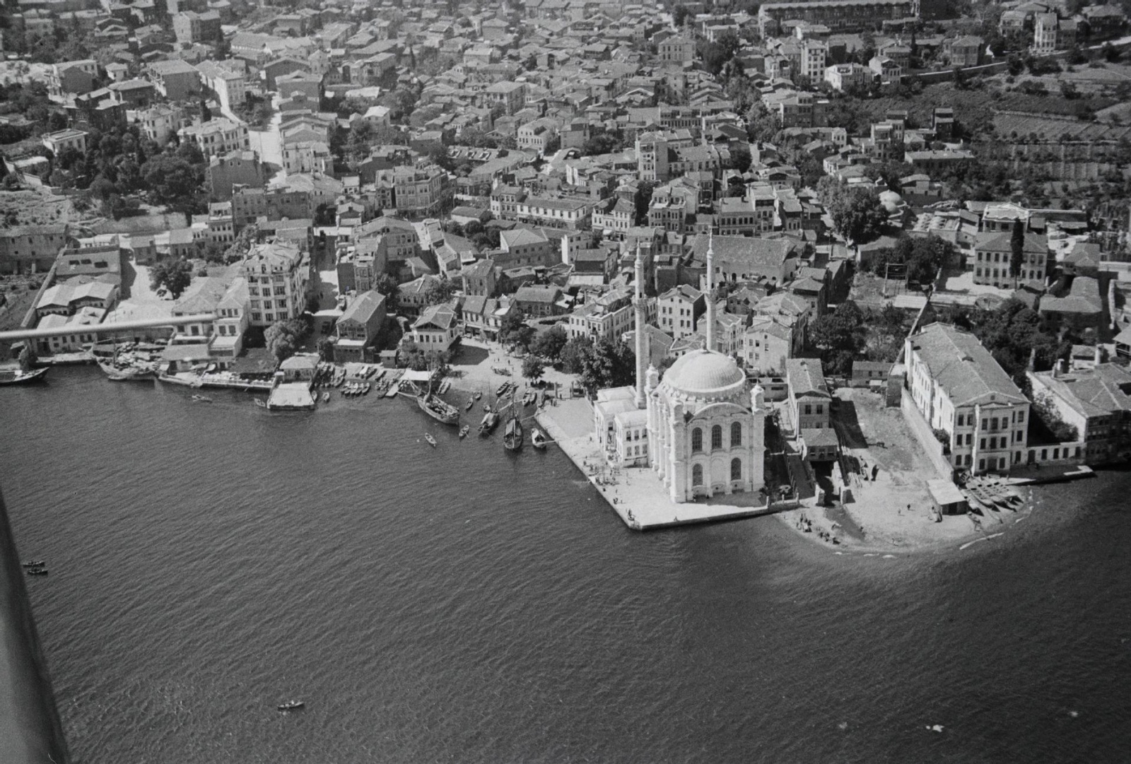 Aerial view of Ortakoy Mosque along the Bosphorus, surrounded by a vibrant neighborhood and small boats docked nearby, Istanbul, Türkiye, June 28, 1934. (Photo via Eski Istanbul)
