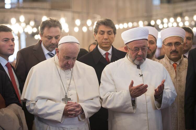 Pope Francis prays with Istanbul's Grand Mufti Rahmi Yaran during a visit to the Sultan Ahmed Mosque, also known as the Blue Mosque, in Istanbul on Nov. 29. (CNS Photo)