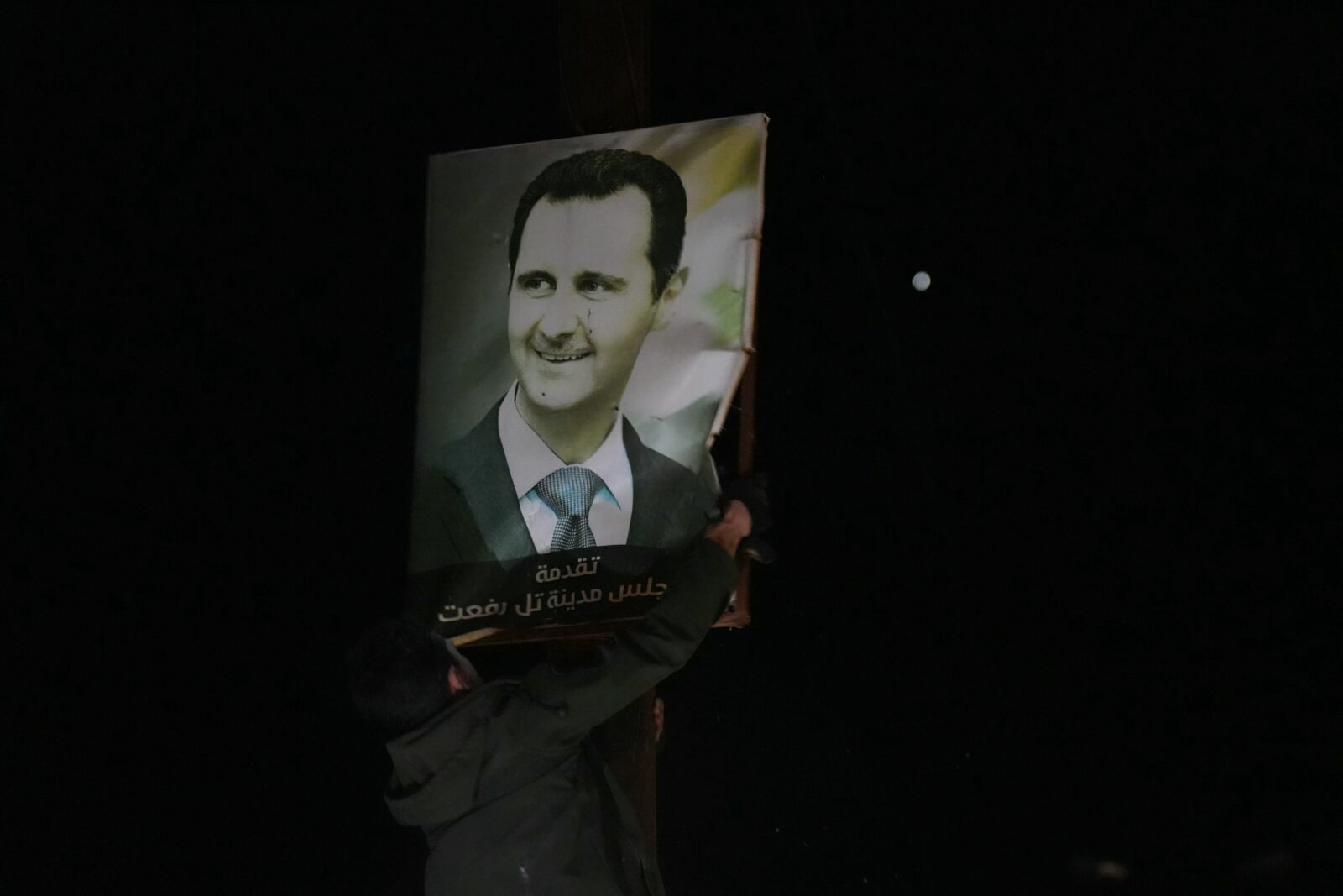 Anti-government fighters tear up a poster of Syrian President Bashar al-Assad as they take over the northern Syrian town of Tal Rifaat on Dec. 1, 2024. (AFP Photo)