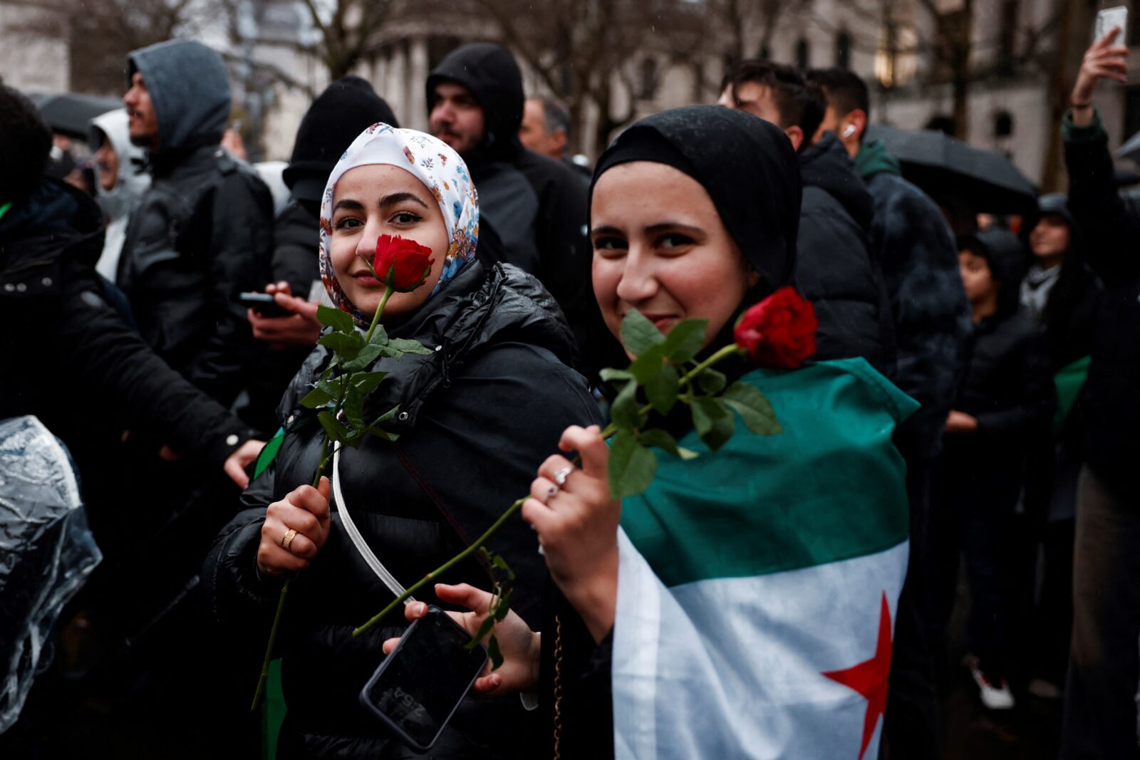 Two demonstrators hold red roses during Syrian community and supporters' celebration of the fall of Syrian president Bashar al-Assad in Trafalgar Square, central London, on December 8, 2024. (AFP Photo)