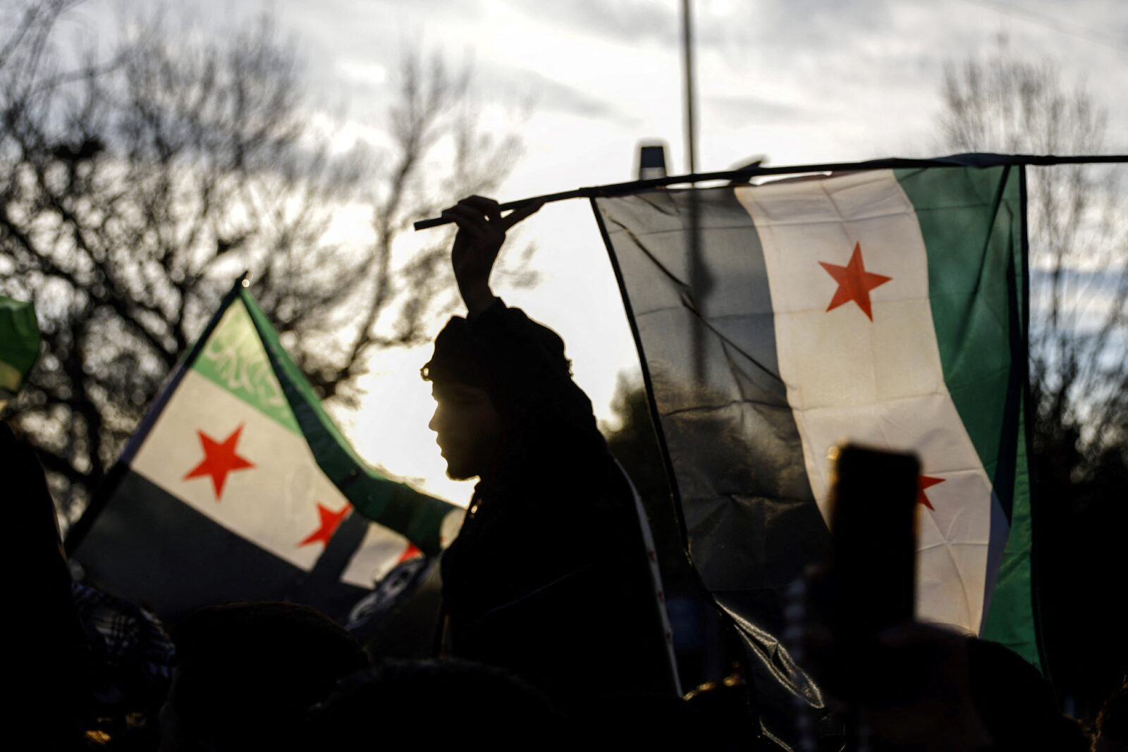 A man waves an opposition flag as members of the Syrian community and supporters gather to celebrate the fall of Syrian president Bashar al-Assad, Istanbul, Türkiye, December 8, 2024. (AFP Photo)