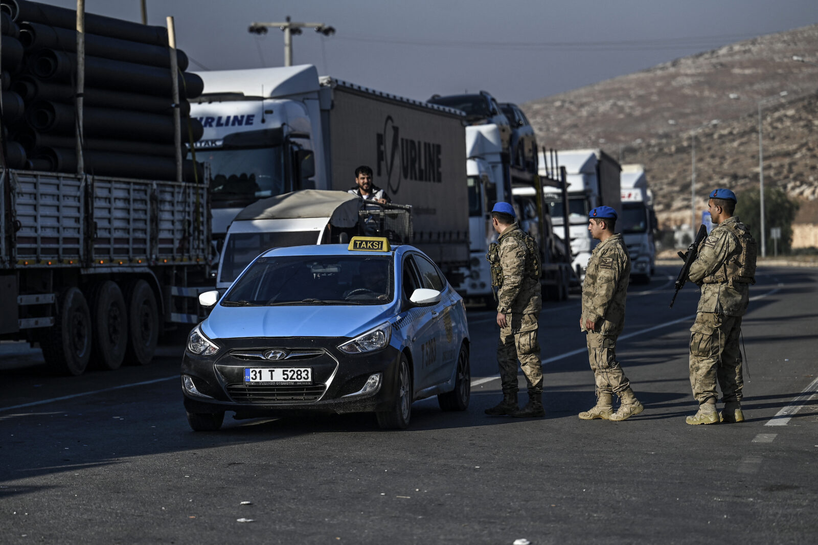 Soldiers controls a taxi as Syrian residents wait in a queue at Cilvegozu crossborder gate before entering in Syria at Reyhanli district in Hatay, on December 9, 2024. - Islamist-led rebels declared on December 8, 2024, that they have taken the Syrian capital in a lightning offensive, sending President Bashar al-Assad fleeing and ending five decades of Baath rule in Syria. (Photo by Ozan KOSE / AFP)Syrian refugees who lives in Turkey arrive with their belongings at Cilvegozu crossborder gate before entering in Syria at Reyhanli district in Hatay, on December 9,2024. - Islamist-led rebels declared on December 8, 2024, that they have taken the Syrian capital in a lightning offensive, sending President Bashar al-Assad fleeing and ending five decades of Baath rule in Syria. (Photo by Ozan KOSE / AFP)Syrian refugees who lives in Turkey arrive with their belongings at Cilvegozu crossborder gate before entering in Syria at Reyhanli district in Hatay, on December 9,2024. - Islamist-led rebels declared on December 8, 2024, that they have taken the Syrian capital in a lightning offensive, sending President Bashar al-Assad fleeing and ending five decades of Baath rule in Syria. (Photo by Ozan KOSE / AFP)A Turkish soldier checks documents as Syrian refugees who lives in Turkey wait at Cilvegozu crossborder gate before entering in Syria at Reyhanli distict in Hatay, on December 9, 2024. - Islamist-led rebels declared on December 8, 2024, that they have taken the Syrian capital in a lightning offensive, sending President Bashar al-Assad fleeing and ending five decades of Baath rule in Syria. (Photo by Ozan KOSE / AFP)
