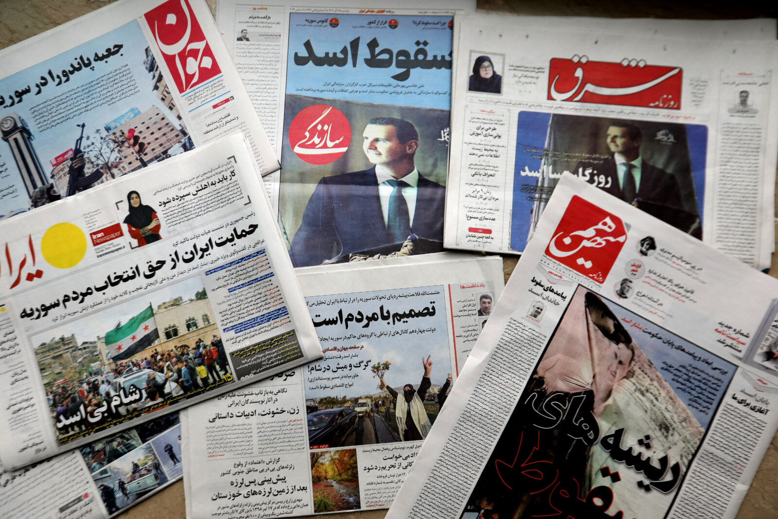 This picture shows newspapers front-pages headlining the fall of Syrian president Bashar al-Assad's rule, in Tehran, on December 9, 2024. - A lightning offensive spearheaded by Islamist rebels ousted Assad from power on December 8, opening a new chapter in Syria's history after five decades of rule by his clan. (Photo by ATTA KENARE / AFP)Members of the Syrian community wave Syrian flags and light flares on December 8, 2024 in Berlin, Germany, and celebrate the end of Syrian dictator Bashar al-Assad's rule after rebel fighters took control of the Syrian capital Damascus overnight. (AFP Photo)
