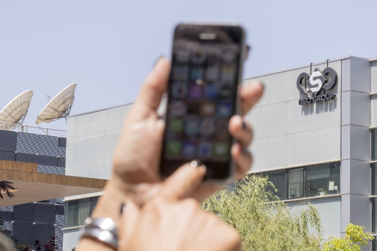 An Israeli woman uses her iPhone in front of the building housing the Israeli NSO group, on August 28, 2016, in Herzliya, near Tel Aviv. (AFP Photo) 