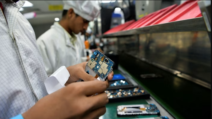 File photo shows line workers in a phone plant in Sriperumbudur, India. (AFP Photo)