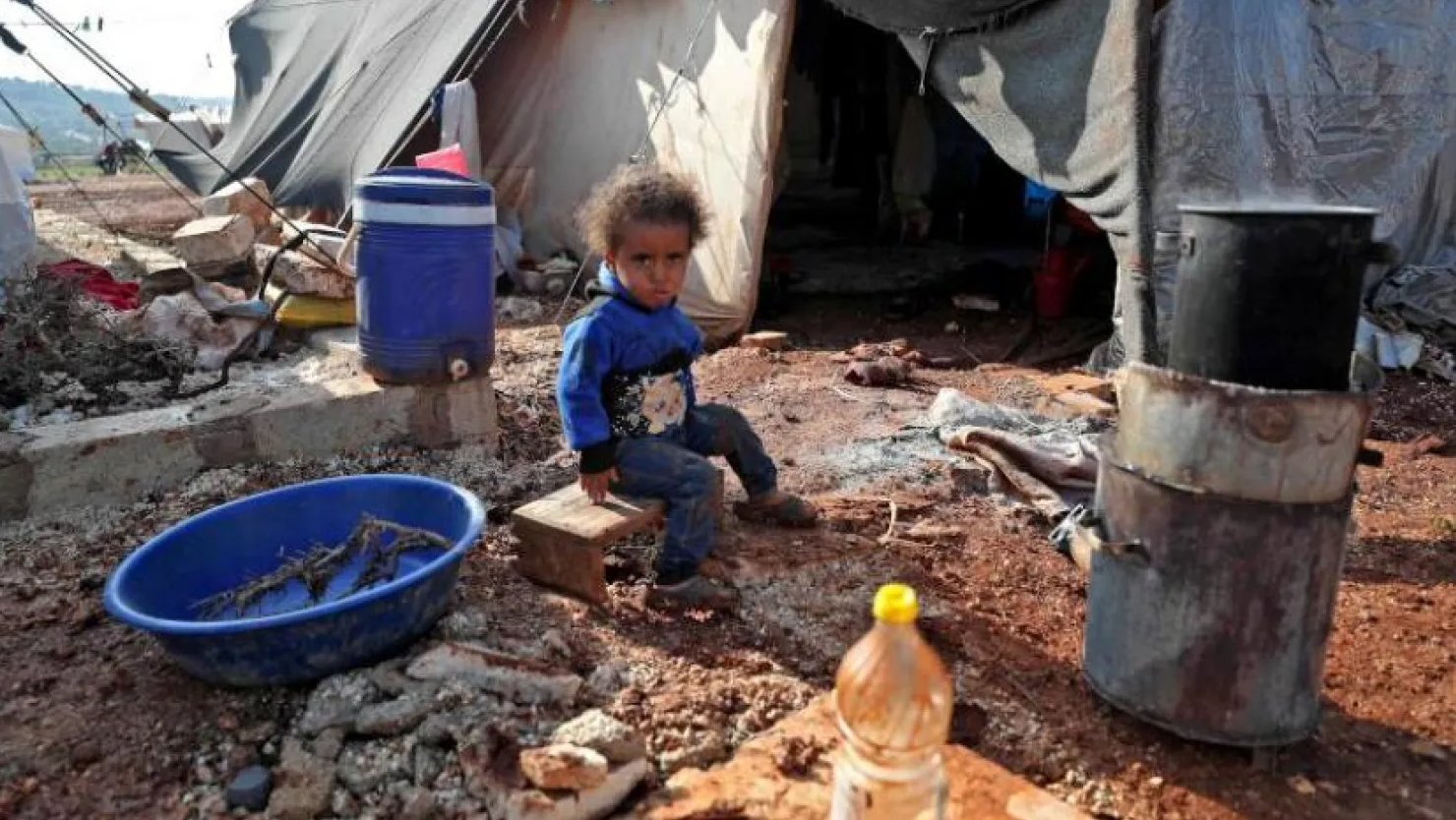 A Syrian child sits outside a tent at a refugee camp in Syria's Idlib province. (AFP Photo)