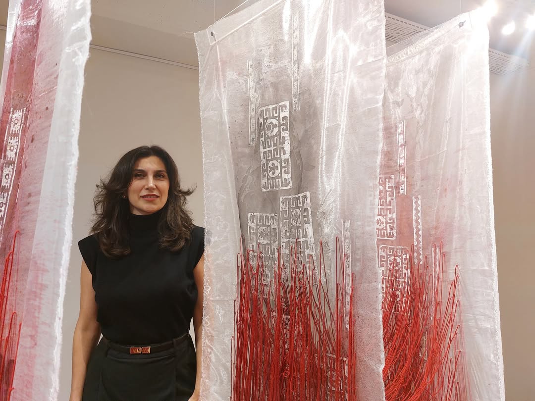 Artist Didem Oz stands among her modern interpretations of Anatolian printing techniques, surrounded by translucent fabrics and bold red accents, Istanbul, Türkiye, Dec. 27, 2024. (Photo via Instagram / @anelsander)