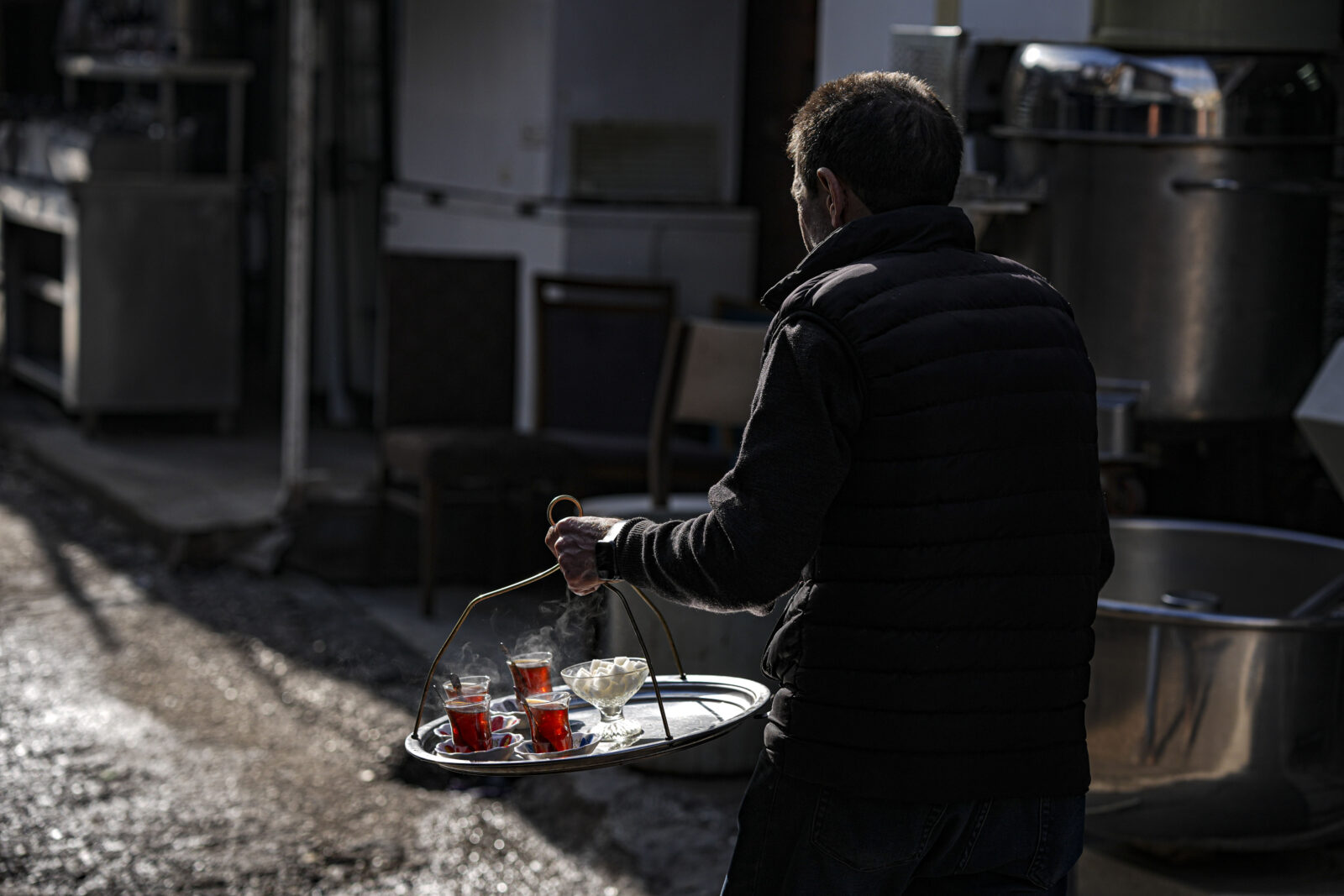 A man distributes Turkish tea to local vendors in the street in the Ulus district of the Turkish capital Ankara, Jan. 18, 2025. (AA Photo)