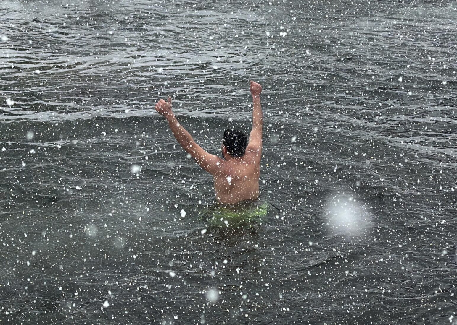 A man plays Tulum (a traditional bagpipe) as people swim in freezingly cold water during the 9th Winter Swimming Festival held under snowfall in Deremezra Village, located within Kackar Mountains National Park in Rize, Türkiye, Jan. 19, 2025. (AA Photo)