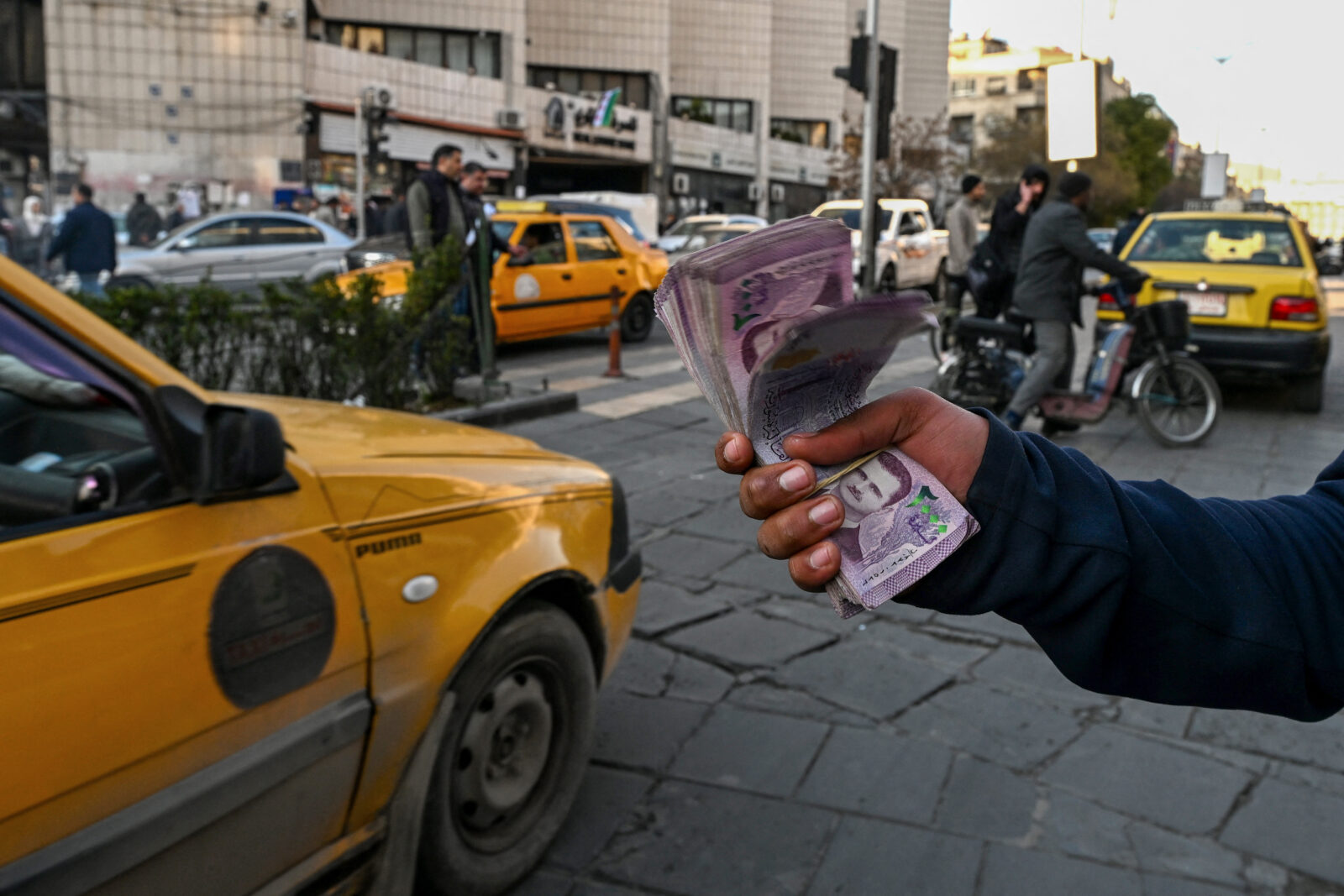 A currency trader offers Syrian liras for exchange on a street in Damascus on Jan. 14, 2025. (AFP Photo)