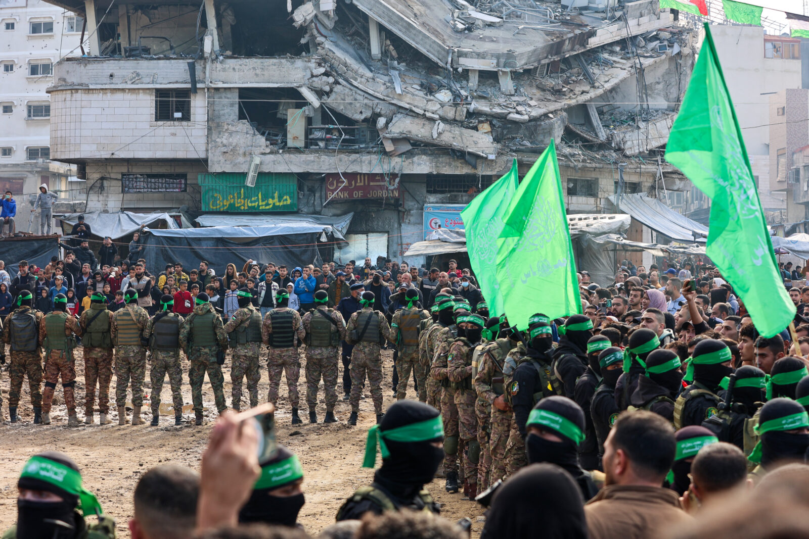 Hamas fighters secure an area in a square before handing over four Israeli hostages to a Red Cross team in Gaza City on January 25, 2025. (AFP Photo)