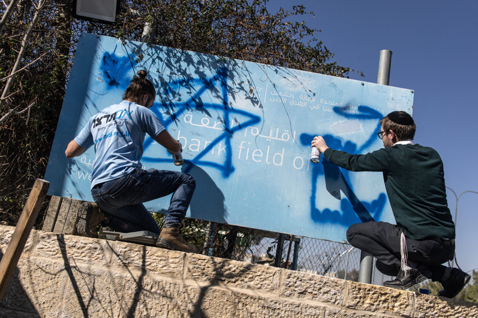 Israeli right-wing activists deface the signboard in front of the shuttered gate of the United Nations Relief and Works Agency UNRWA's West Bank Field Office in Jerusalem on Jan. 30, 2025. (AFP Photo)