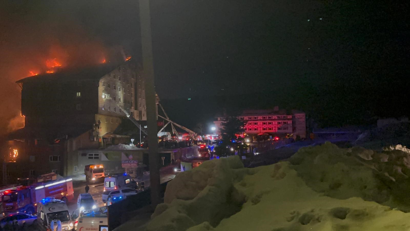 Firefighters and emergency vehicles are seen responding to a large fire engulfing a hotel at Kartalkaya Ski Resort in Bolu, Türkiye, on Jan. 21, 2025. (IHA Photo)