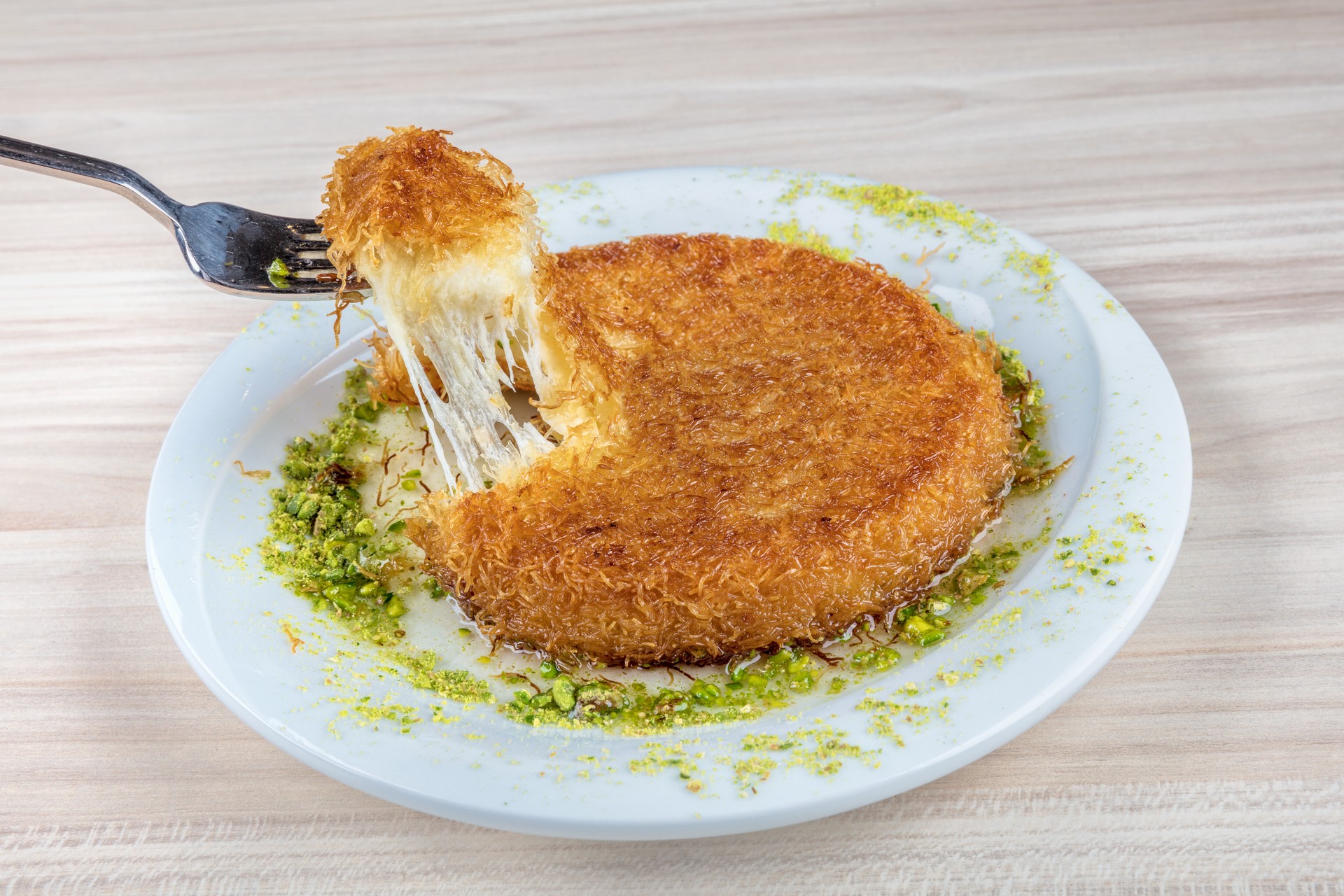 Kunefe, a beloved Turkish dessert, combines crispy kadayif dough with melted cheese and sweet syrup. (Adobe Stock Photo)