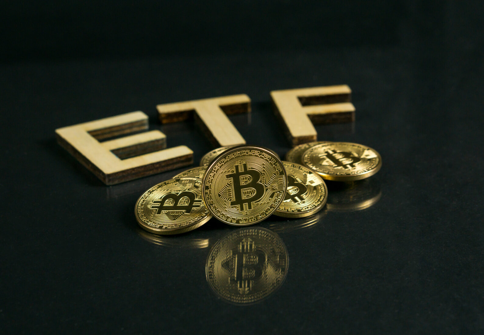 The file photo shows a Bitcoin coin with ETF text put on the wooden floor, (Adobe Stock Photo)