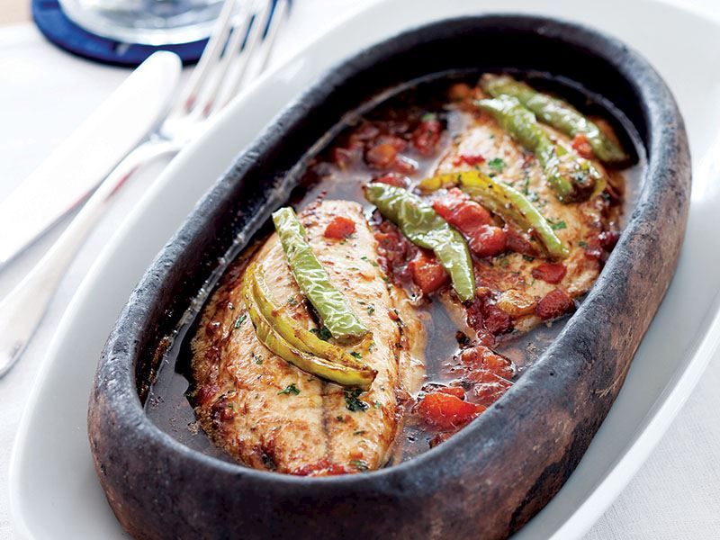 A plate made of clay with oven-baked bonito. The fig leaves mentioned in the recipe are not present in this photo. (Photo via Pinterest)