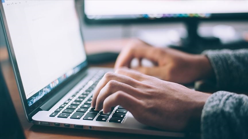 File photo shows a person typing on a laptop, representing work activity. (AA Photo)