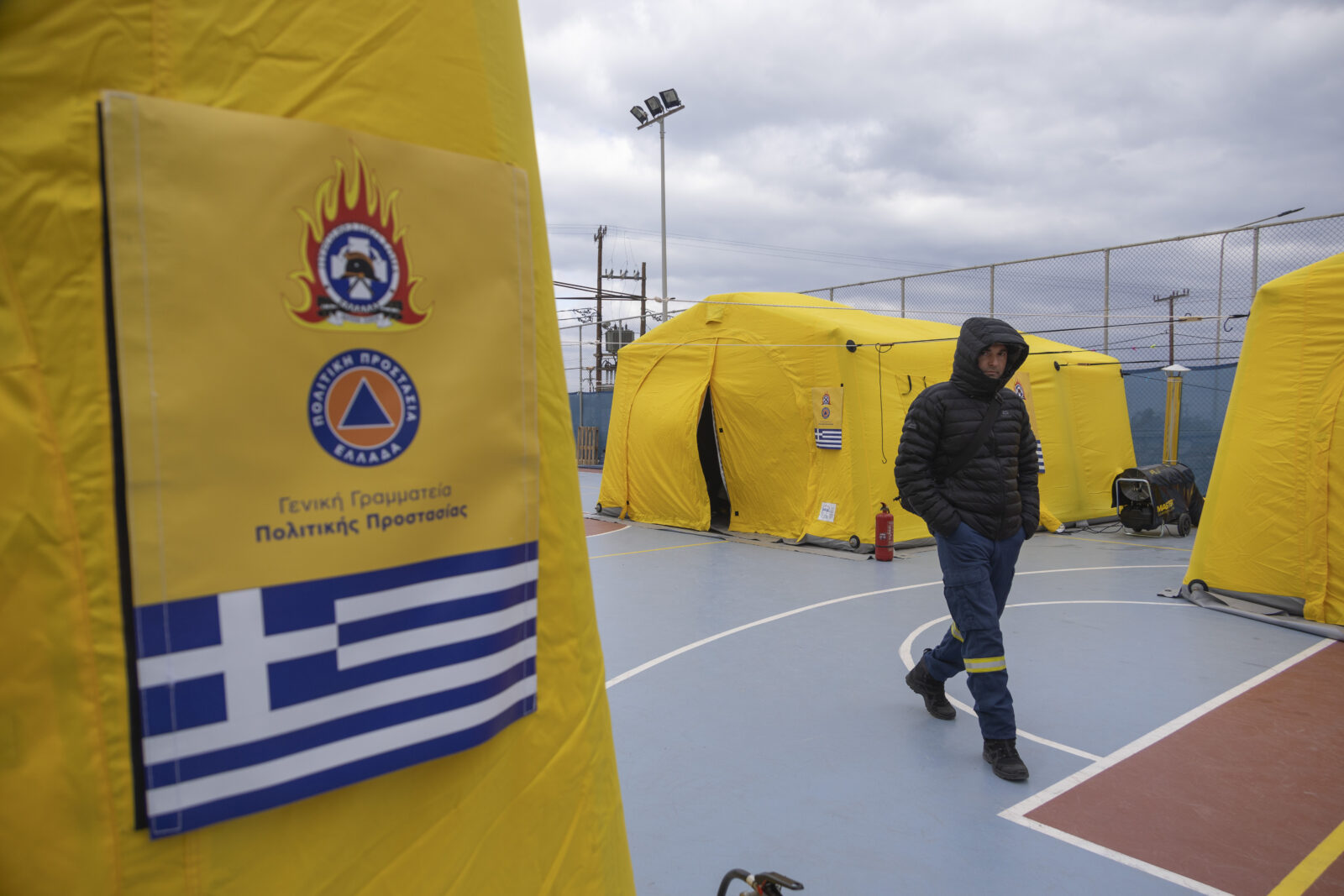 A firefighter from the special disaster response unit walking past temporary emergency tents set up for rescue crews in Fira, Santorini Island, Greece, Feb. 21, 2025. (AA Photo)