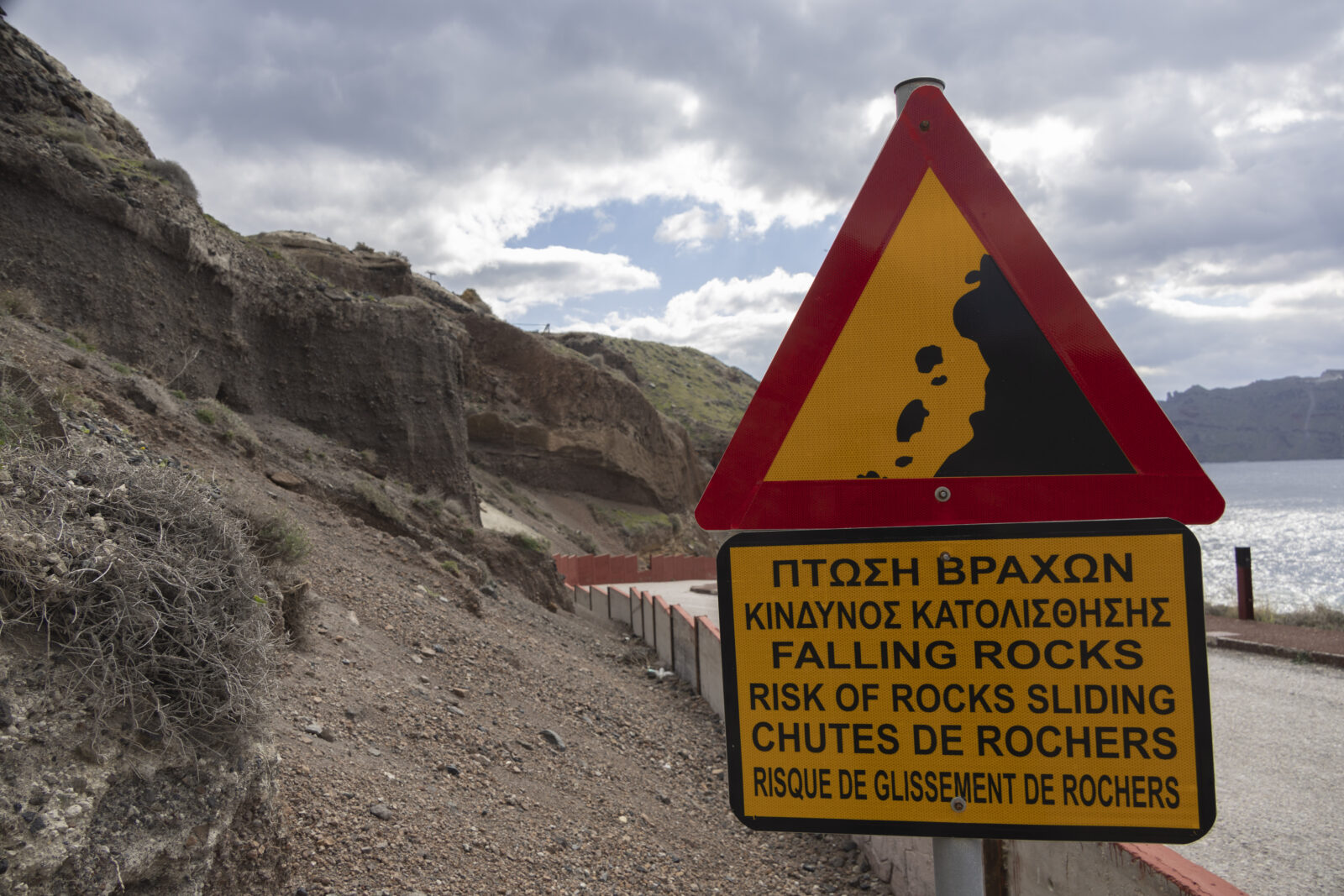 A warning sign cautioning about falling rocks near the cliffs in Ammoudi on Santorini Island, where earthquakes continue to occur at a decreasing rate, Greece, February 21, 2025. (AA Photo)