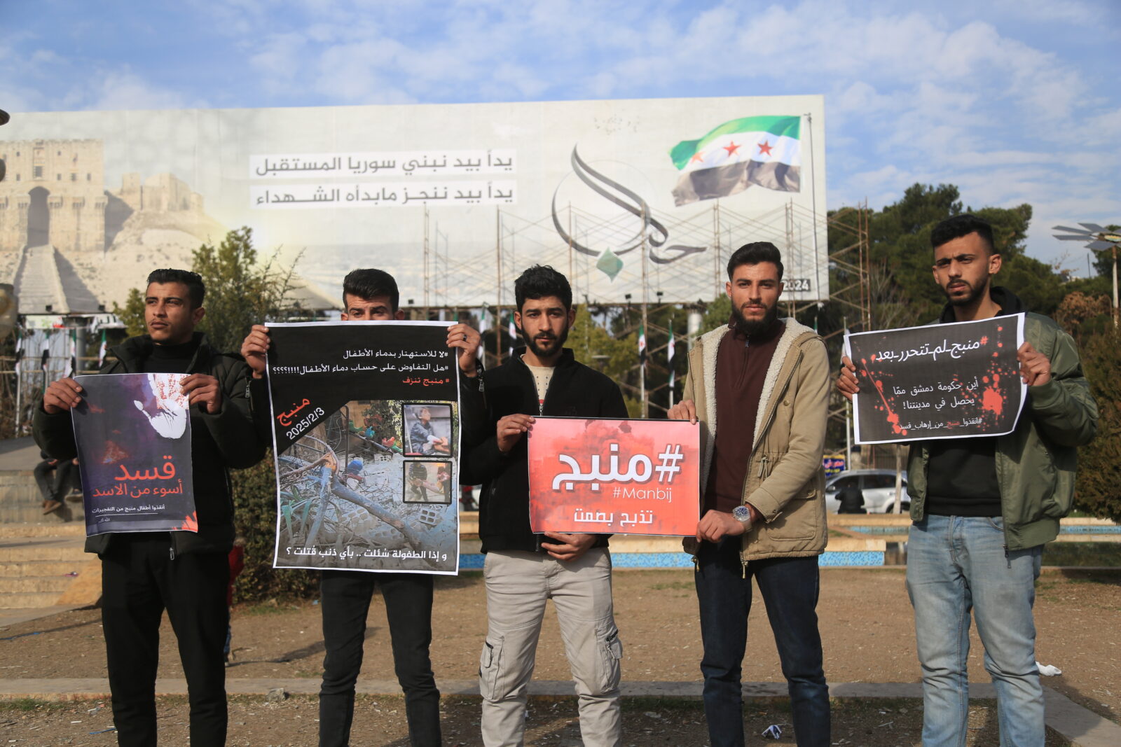 Hundreds of civilians participated in the demonstration, holding signs in Arabic and English with messages such as 