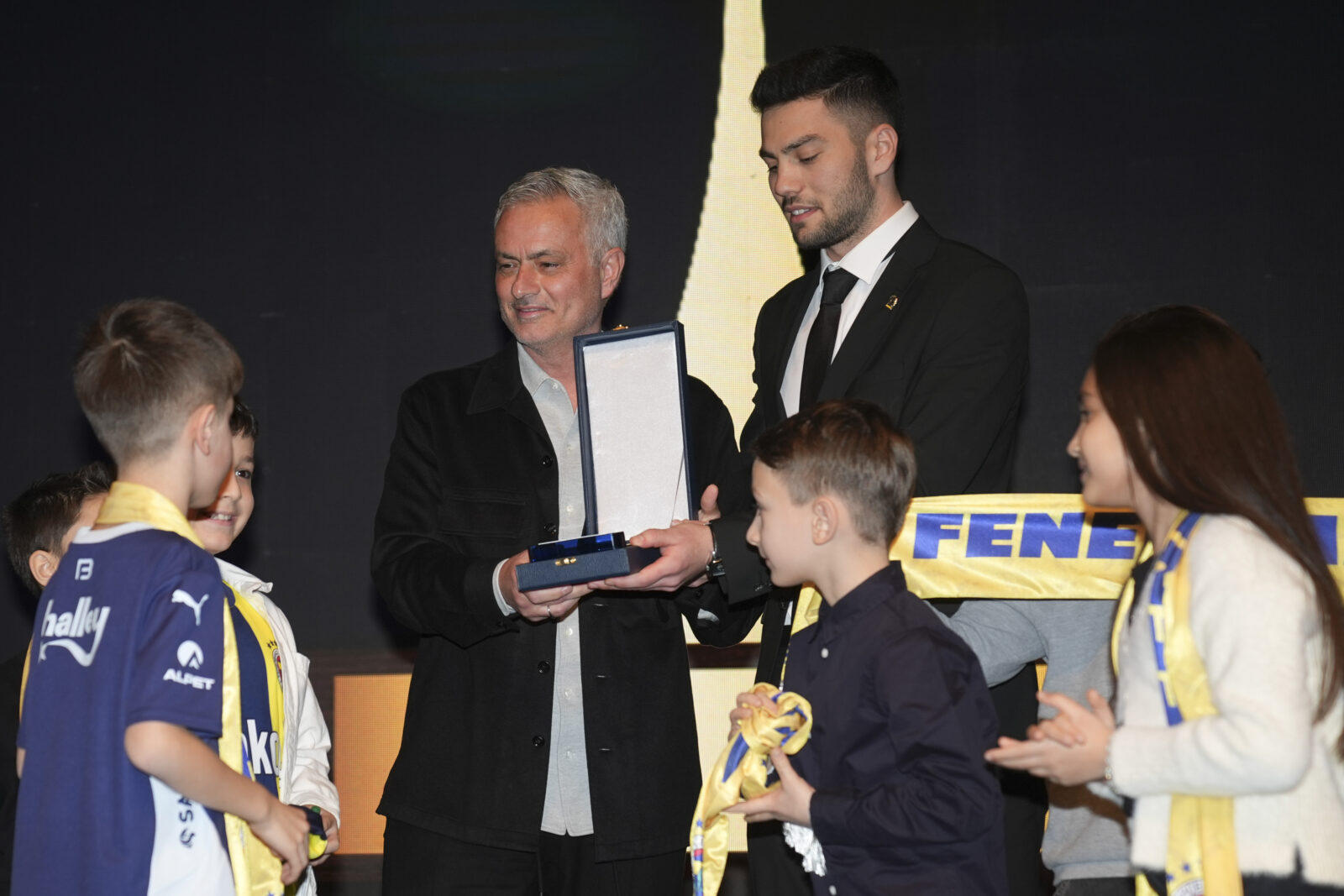 Fenerbahce's head coach Jose Mourinho (C-L) poses with children as he receives the 