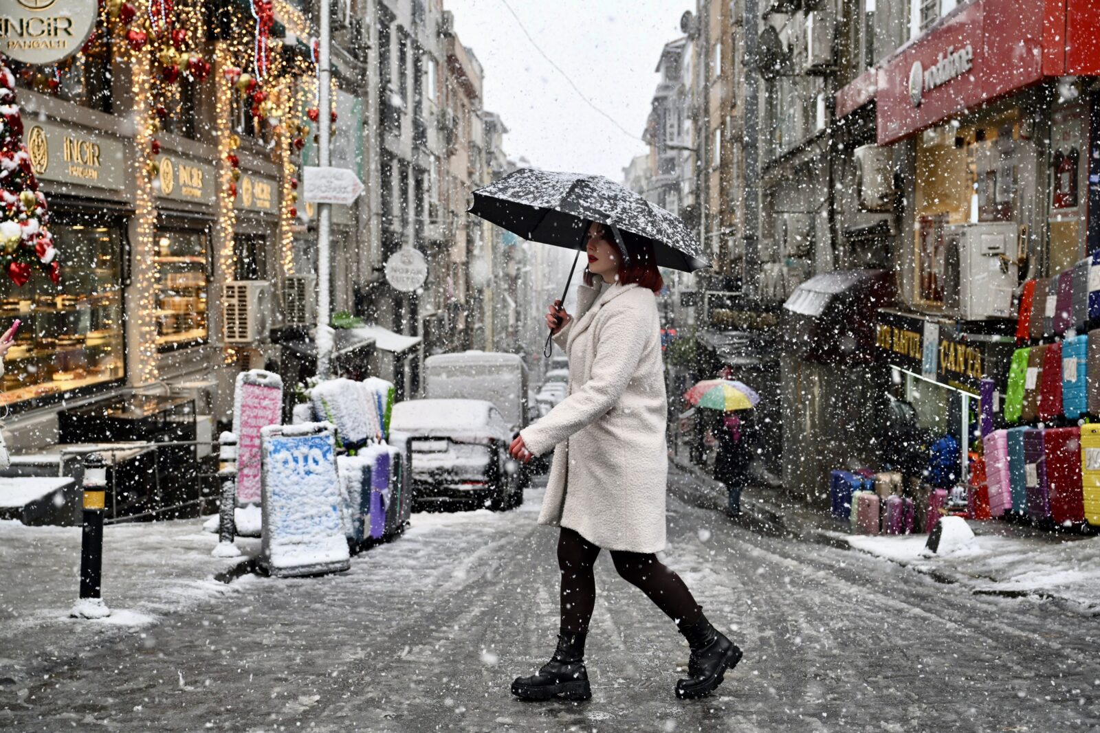 People walk as snow falls in Sisli, Istanbul, Türkiye. (AA Photo)